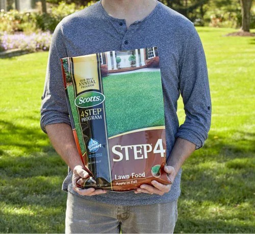 a man holds a bag of Scotts Step 4